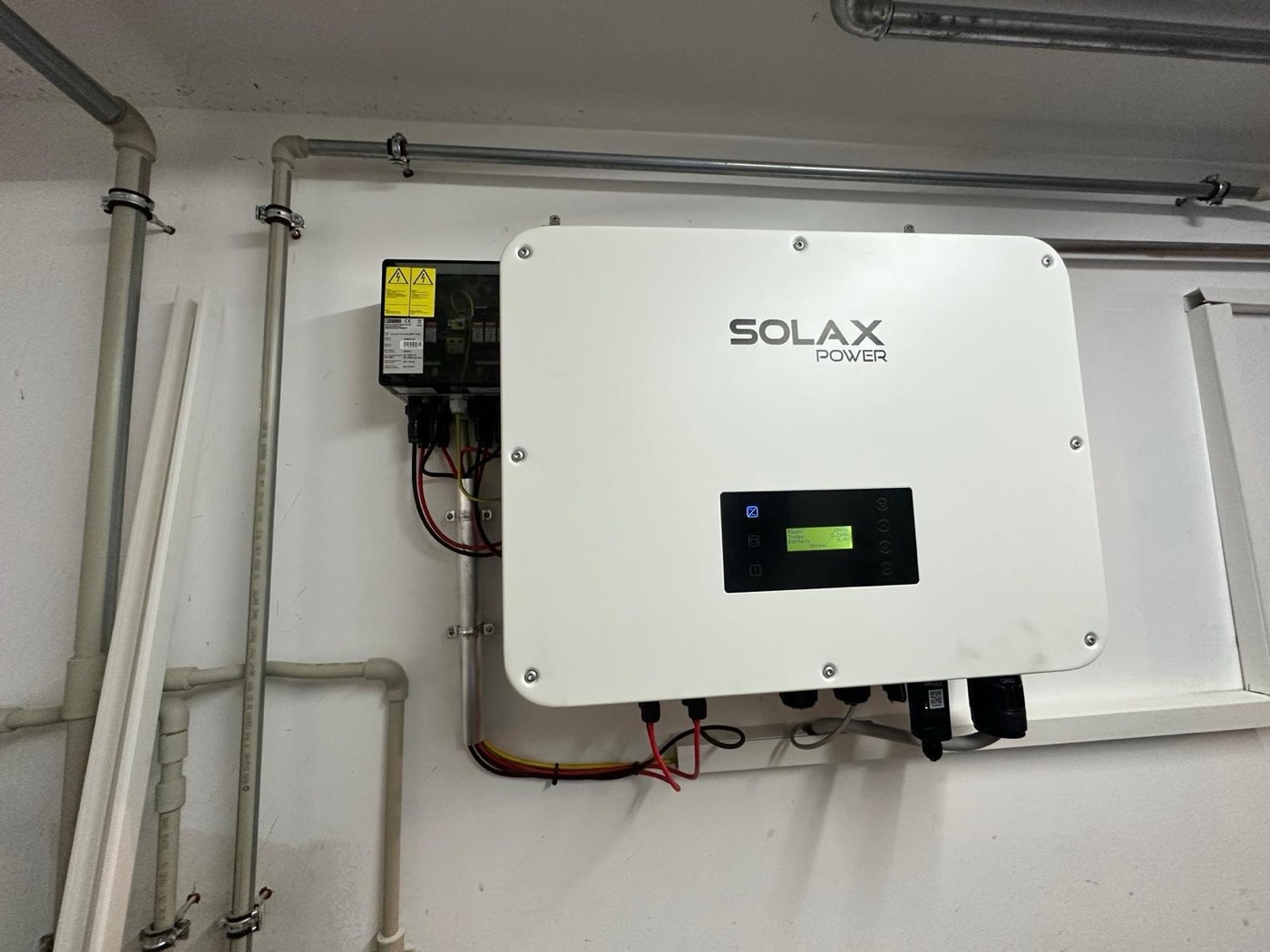 SolaX Power Wechselrichter mit Display, sauber verkabelt neben dem DC-Trennschalter